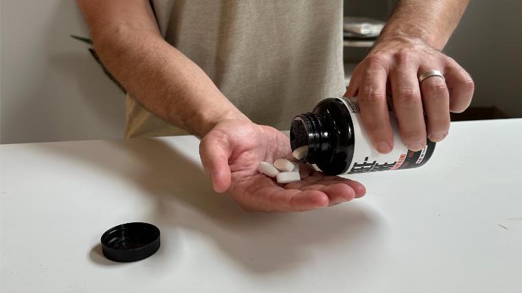 A BarBend tester with a handful of Crazy Muscle Creatine Pills