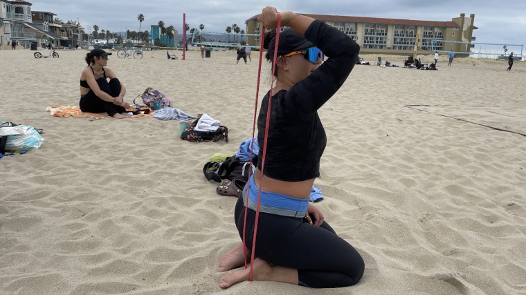 Our BarBend Tester warms up triceps with one of the Fringe Sport Resistance Bands. 