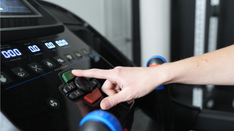 a person touching the start button on the console of the Horizon 7.0 AT Treadmill