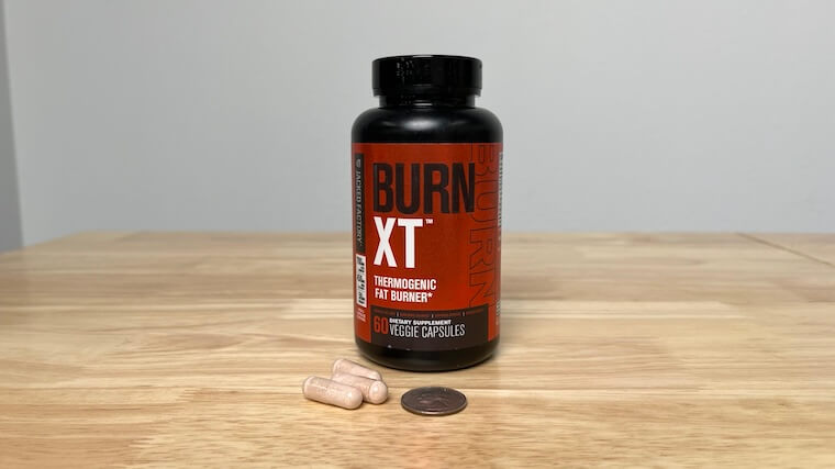 The size of Jacked Factory Burn XT capsules compared to a coin