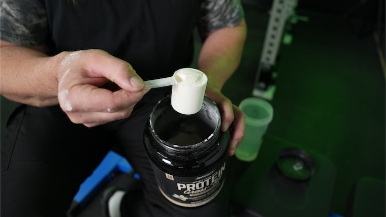 Our tester grabbing a scoop of Onnit Grass-Fed Protein