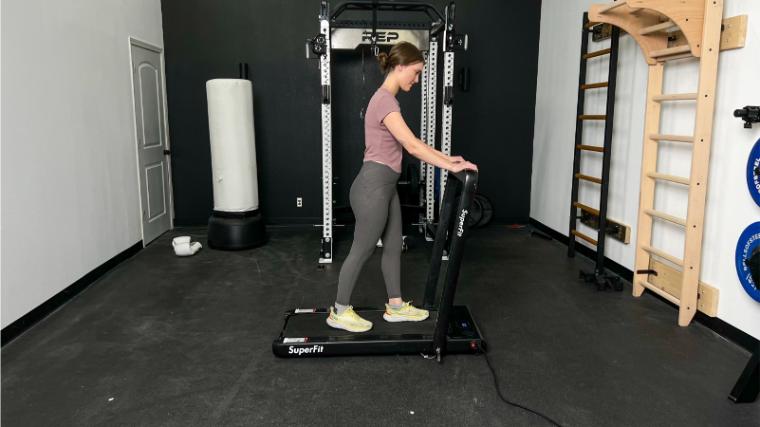 A BarBend tester walking on the Goplus 2-in-1 Folding Treadmill.