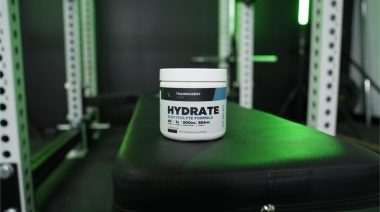 a container of Transparent Labs Hydrate on a bench in the BarBend gym