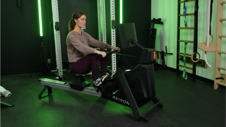 A BarBend tester on the Aviron Strong Rowing Machine.