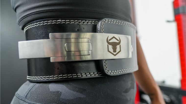 A person wears an Iron Bull weightlifting belt.